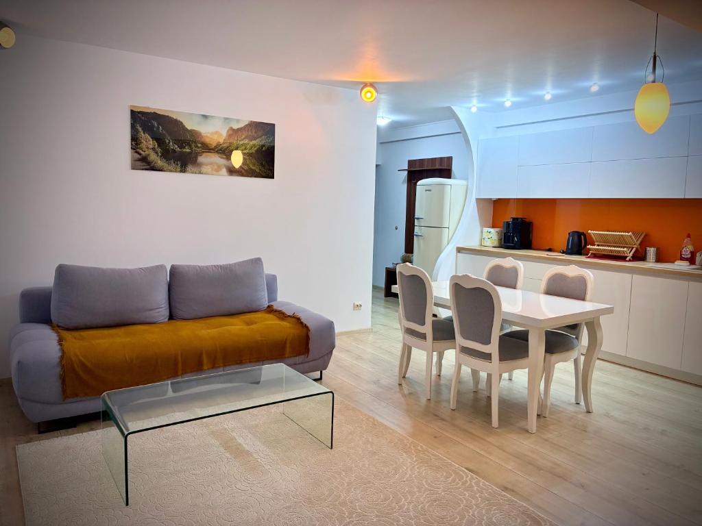 a living room with a couch and a table and a kitchen at YamaLuxe Apartments - Super Cozy in Cluj-Napoca
