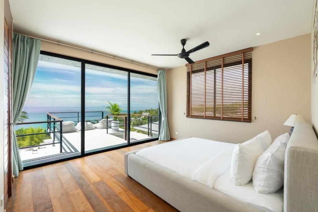 a bedroom with a bed and a large window at Tahiana Villa in Haad Tian