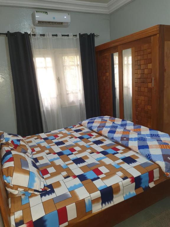 a bed with a colorful quilt in a bedroom at Mifa, Appartement RDC de 2 chambres, pour famille in Dakar