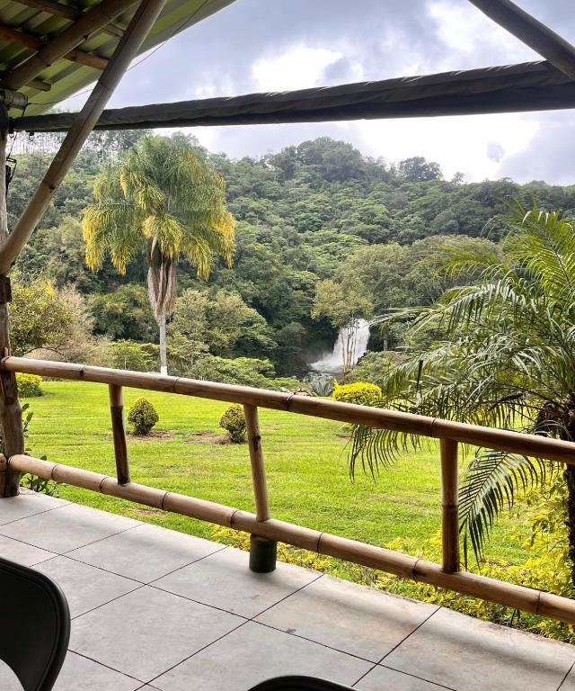 ein Balkon mit Blick auf einen Wasserfall und Bäume in der Unterkunft OYO Hotel Rincon De Texolo, Xico in Xico