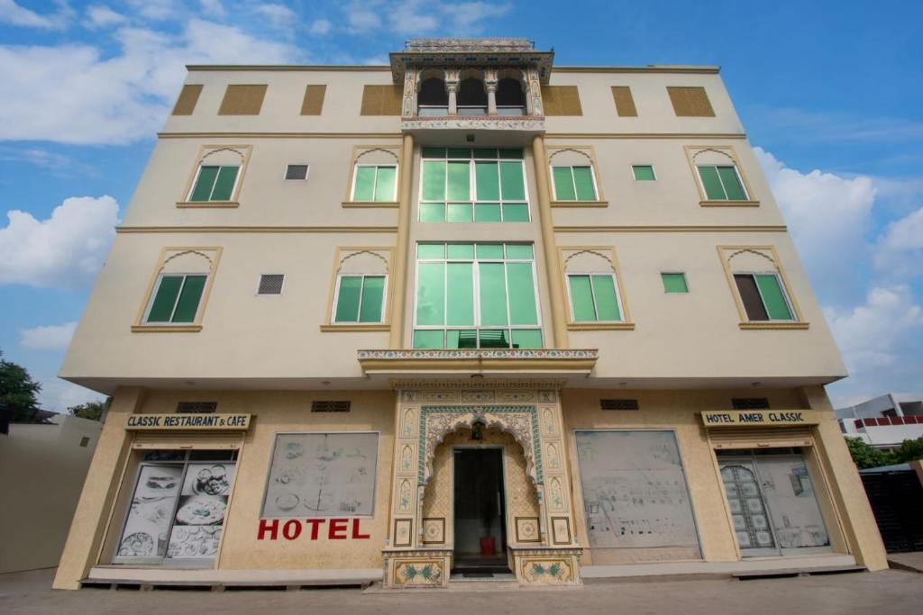 a tall building with a hotel on top of it at Amer Classic - A Heritage Stay Near Amer Fort in Jaipur