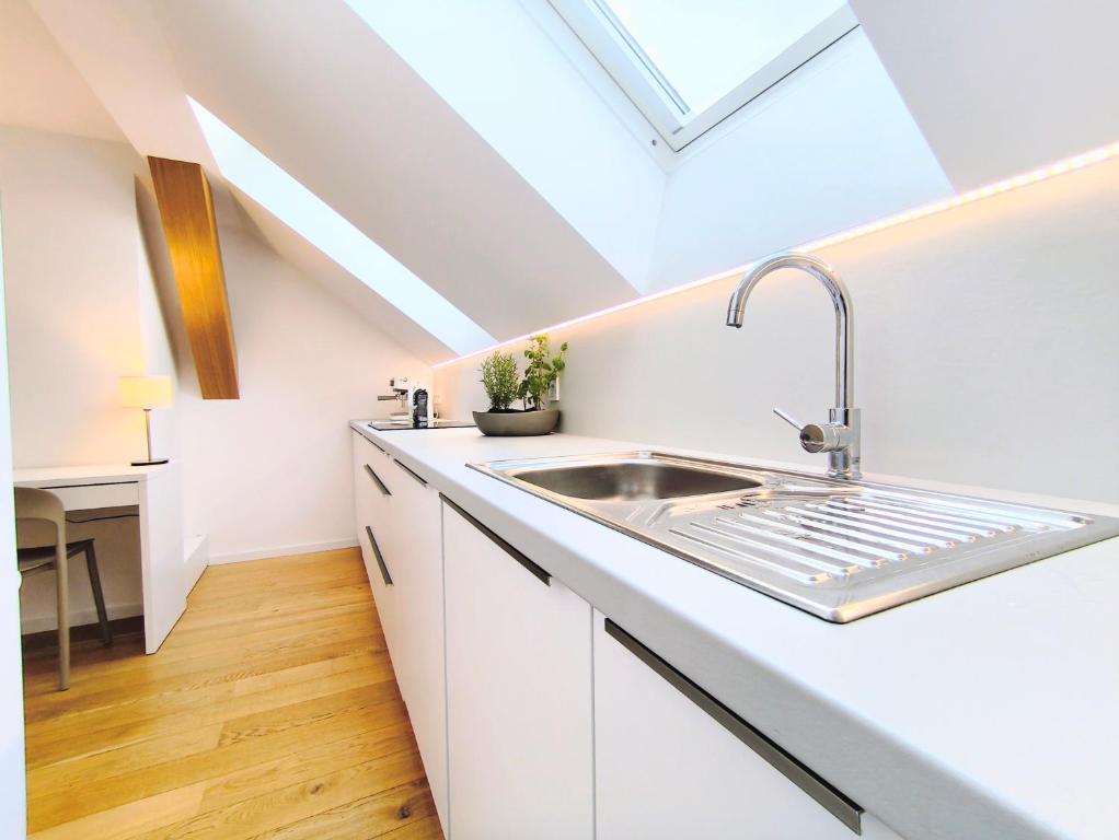 波普拉德Apartment Poprad - Tatra Elegant, Near High Tatras, Free Parking, Modern Stay的厨房设有水槽和天窗。