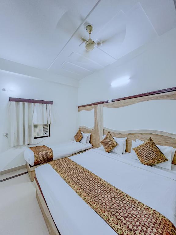 a bedroom with two beds and a tv on the wall at Hotel The Golden Bird Executive in Agra