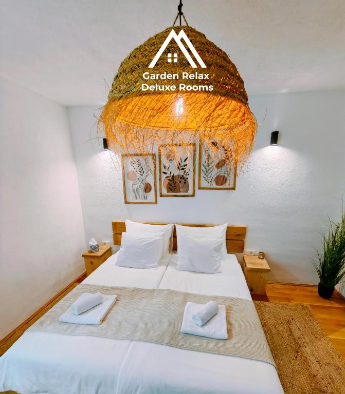 a bedroom with a large bed and a chandelier at Garden Relax Bungalow "Deluxe Hotel Rooms, Pool, Parking" in Banja Luka
