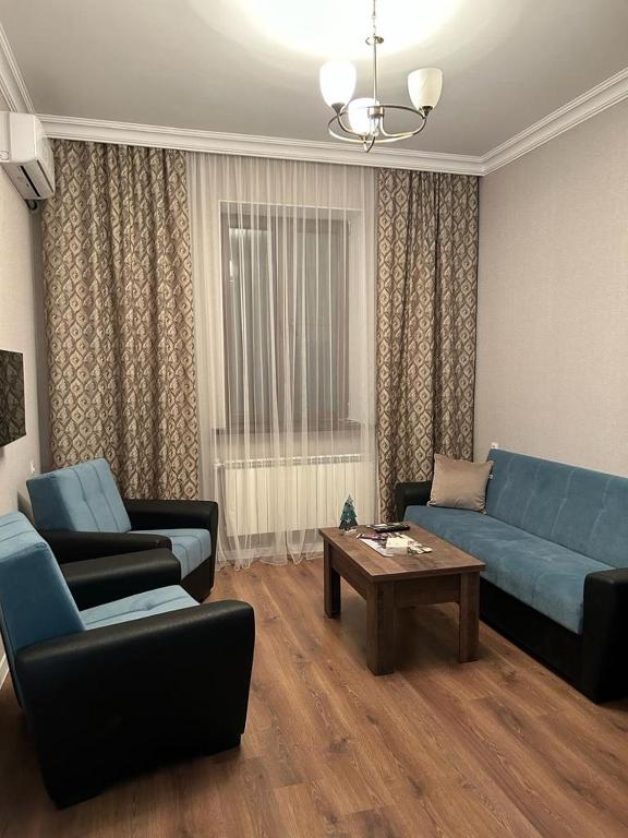 a living room with a blue couch and a table at АПАРТАМЕНТ 124 у метро in Yerevan