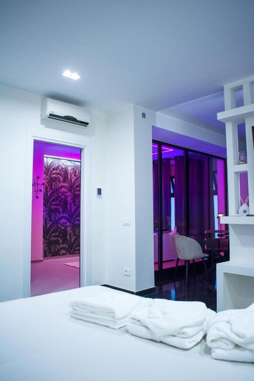 a white room with a bed and a purple door at Crystal Luxury Apartment in Capurso