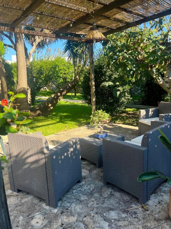 an outdoor patio with chairs and an umbrella at Terra Di Mare in Vignacastrisi