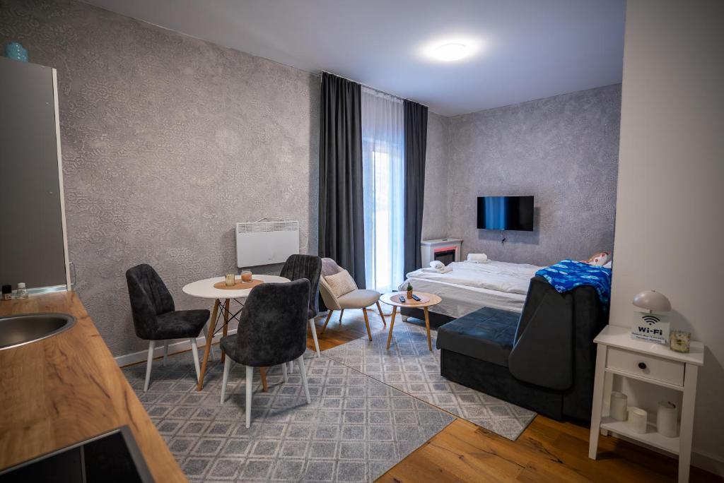 een hotelkamer met een bed, een tafel en stoelen bij Mountain goat Bjelašnica in Bjelašnica