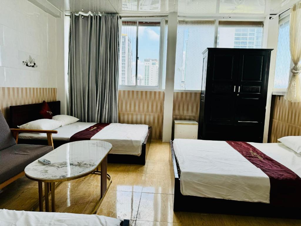 a hotel room with two beds and a couch at Tuệ Tĩnh in Nha Trang