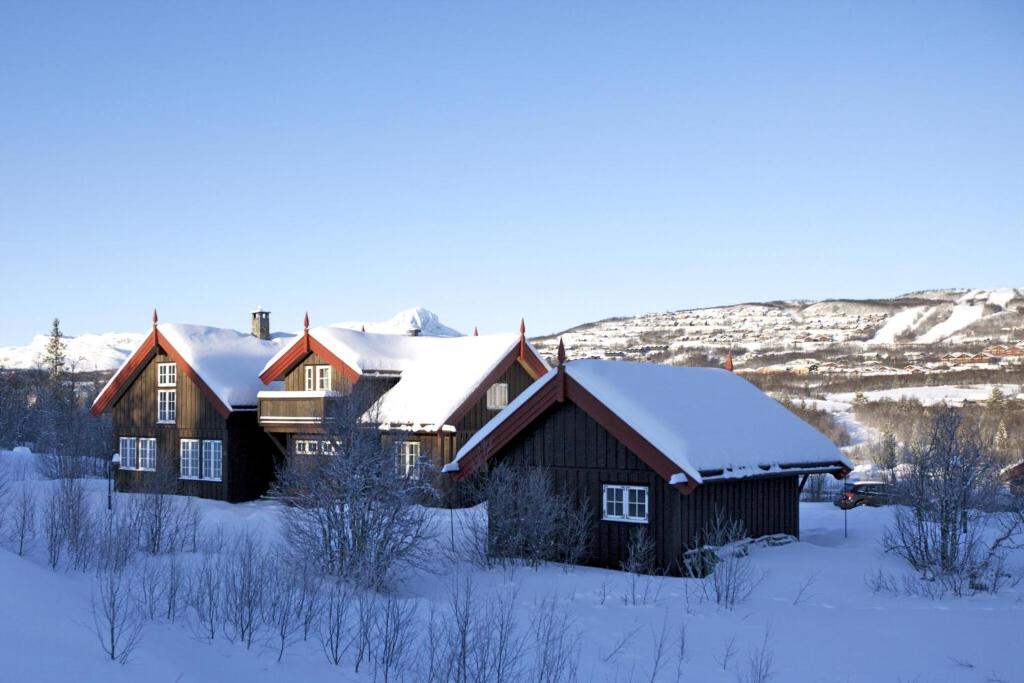 una casa en la nieve con techos cubiertos de nieve en Grand Log Cabin With Fireplace And 12-14 Beds, en Beitostølen