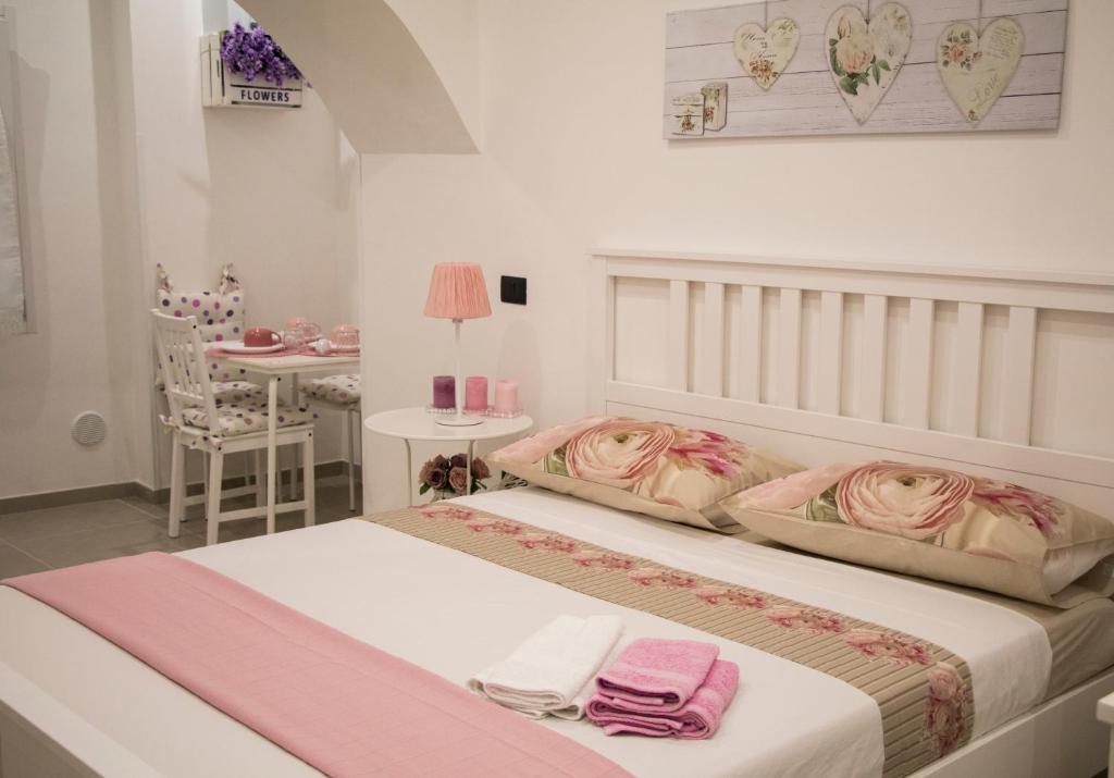 una camera con due letti e asciugamani rosa di Salerno nel Cuore a Salerno