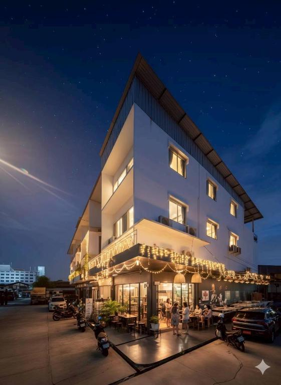 a building with people sitting outside of it at night at Youyen Hostel in Ban Don Muang