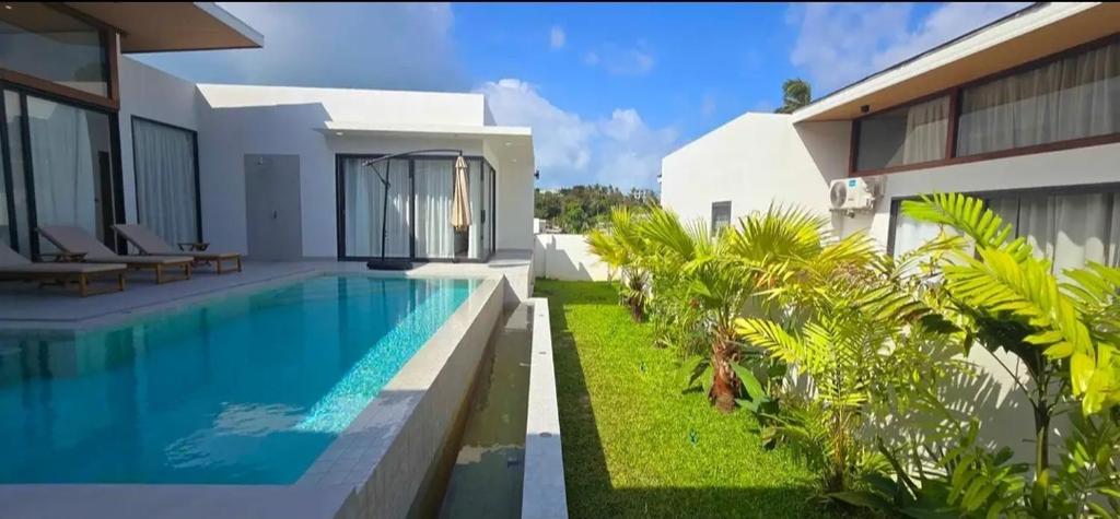 a villa with a swimming pool next to a house at Samui Luxury villas -By Samui Rental Villas in Amphoe Koh Samui
