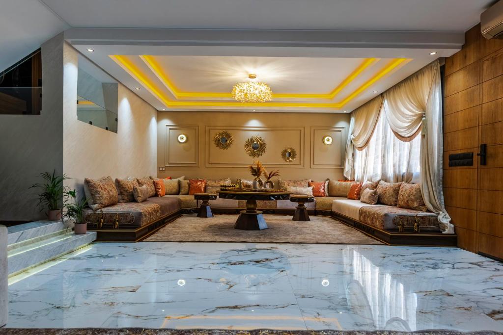 a living room with couches and a table at Modern Luxury Villa Heart of Central agadir in Agadir