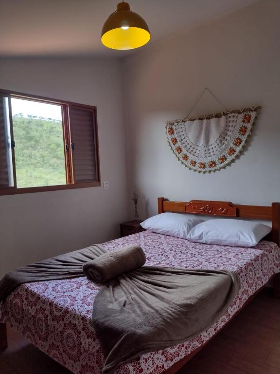 a bedroom with two beds with a window and avertisement at Serra da Capela in São José da Barra