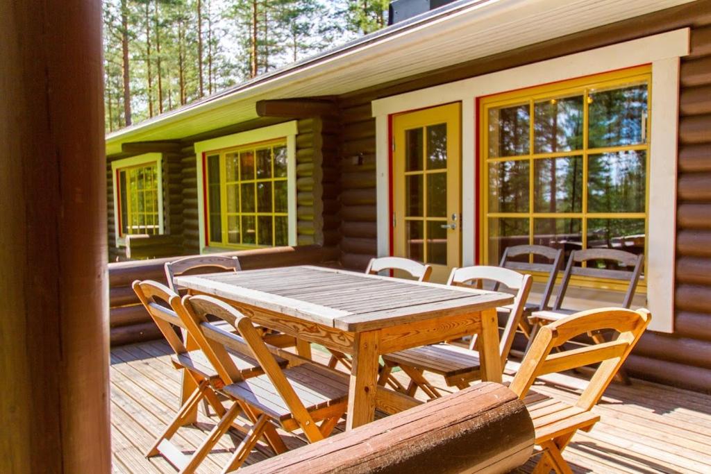 einen Holztisch und Stühle auf einer Holzterrasse in der Unterkunft Koli Iso-Ryläys in Kolinkylä