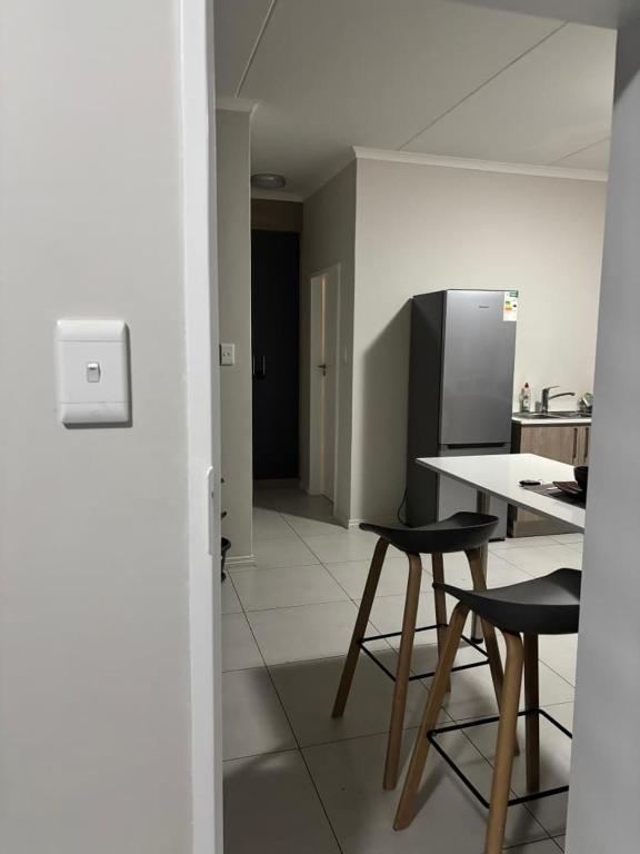 a kitchen with a table and chairs and a refrigerator at Bojame in Gaborone