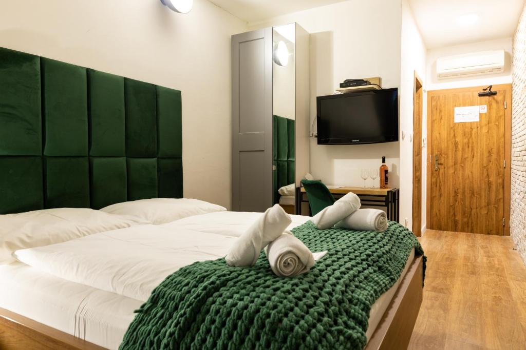 a bedroom with a large bed with a green blanket at Penzión u Vinára in Veľký Krtíš