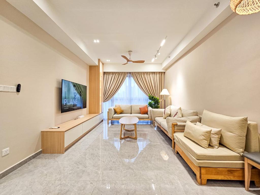 a living room with two couches and a tv at La Gente X Agile Bukit Bintang Trx Pavilion Kl in Kuala Lumpur