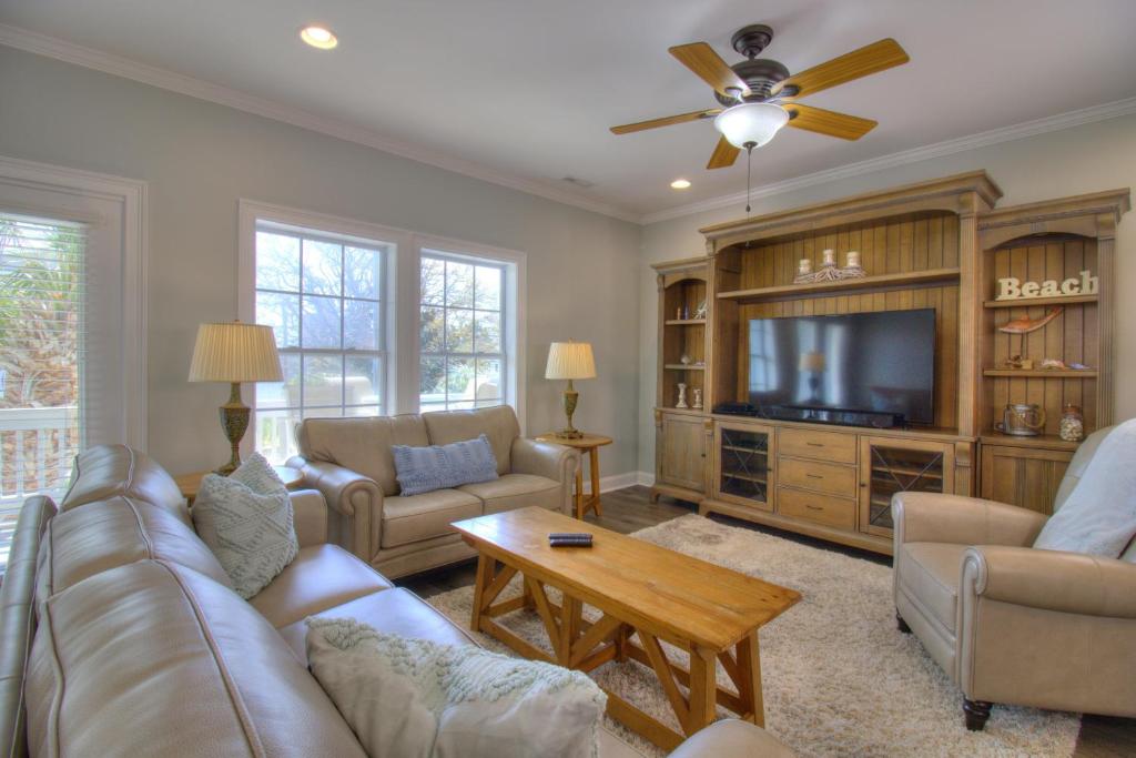 a living room with a couch and a tv at Stairway to Havens - South in Myrtle Beach