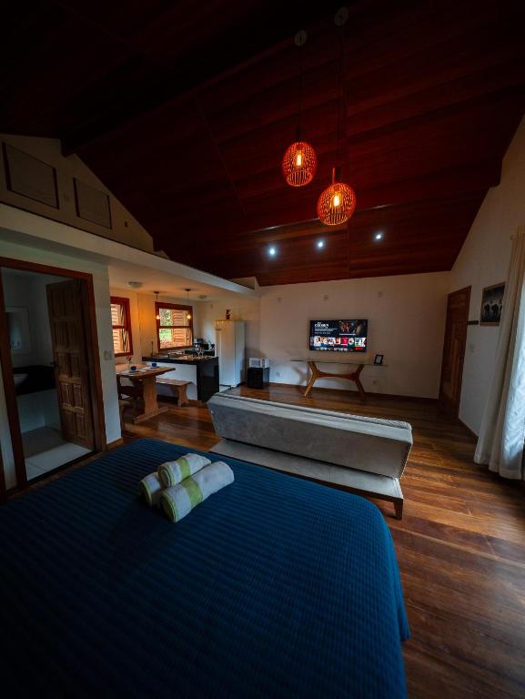 a bedroom with a large bed and a tub at Chalé Brandt Huss in Santa Teresa
