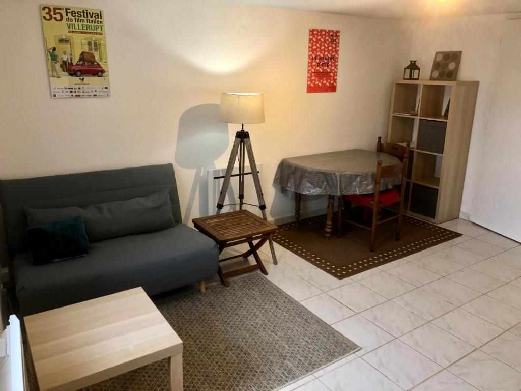 ein Wohnzimmer mit Sofa und Tisch in der Unterkunft Calme et confort, avec 2 lits ,à la frontière in Audun-le-Tiche