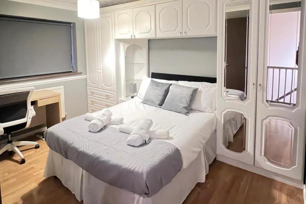 a bedroom with a large white bed with towels on it at 3-Bed House - Sleeps 6 Parking & Garden in Grays Thurrock