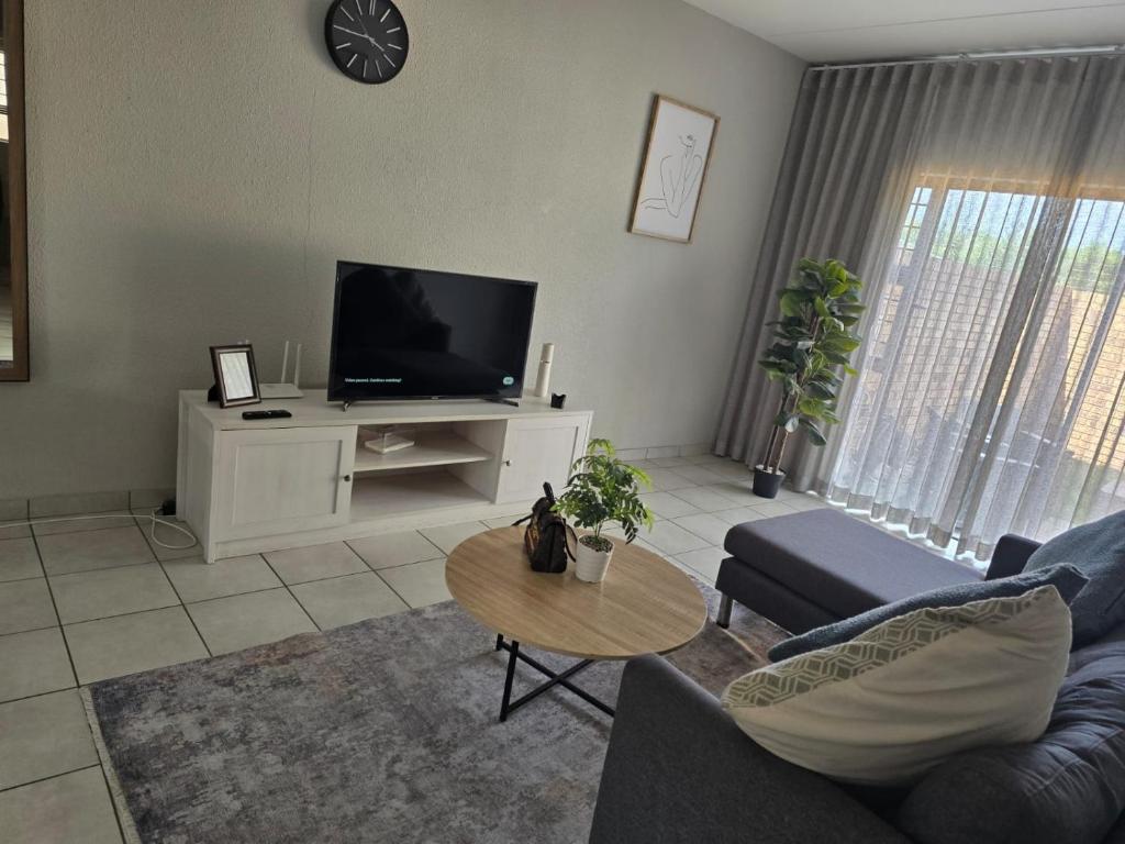 a living room with a couch and a tv at Yanaz Place in Germiston