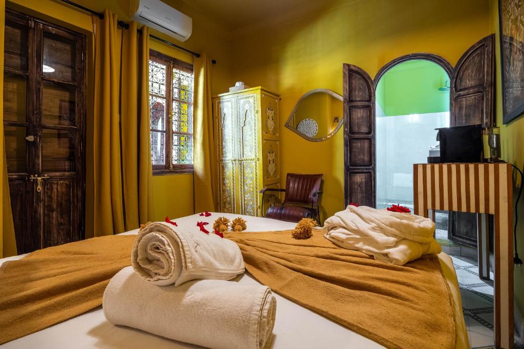 Un dormitorio con una cama con toallas. en Dar Khmissa Riad & Spa, en Marrakech