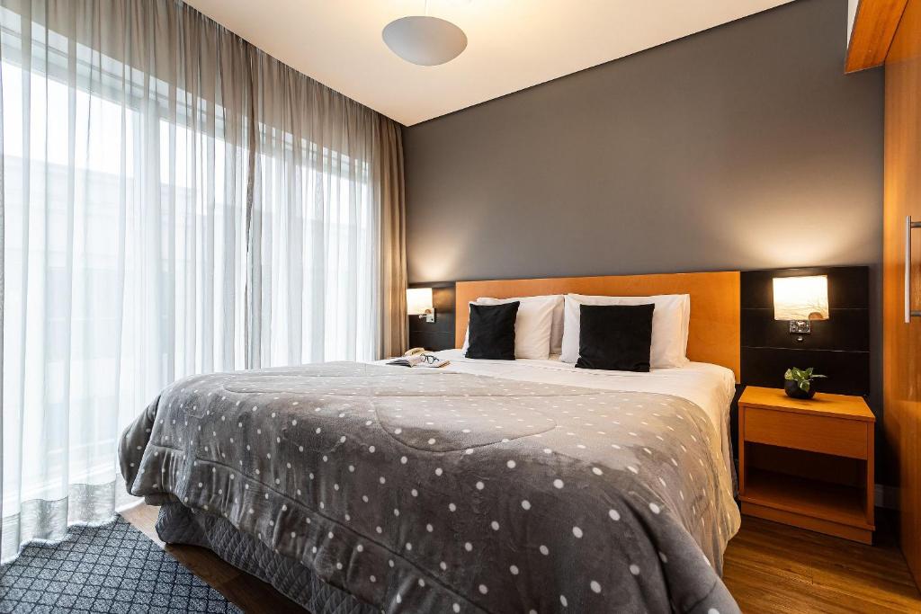 a bedroom with a bed and a large window at Flat Parque do Ibirapuera - Jardins in São Paulo
