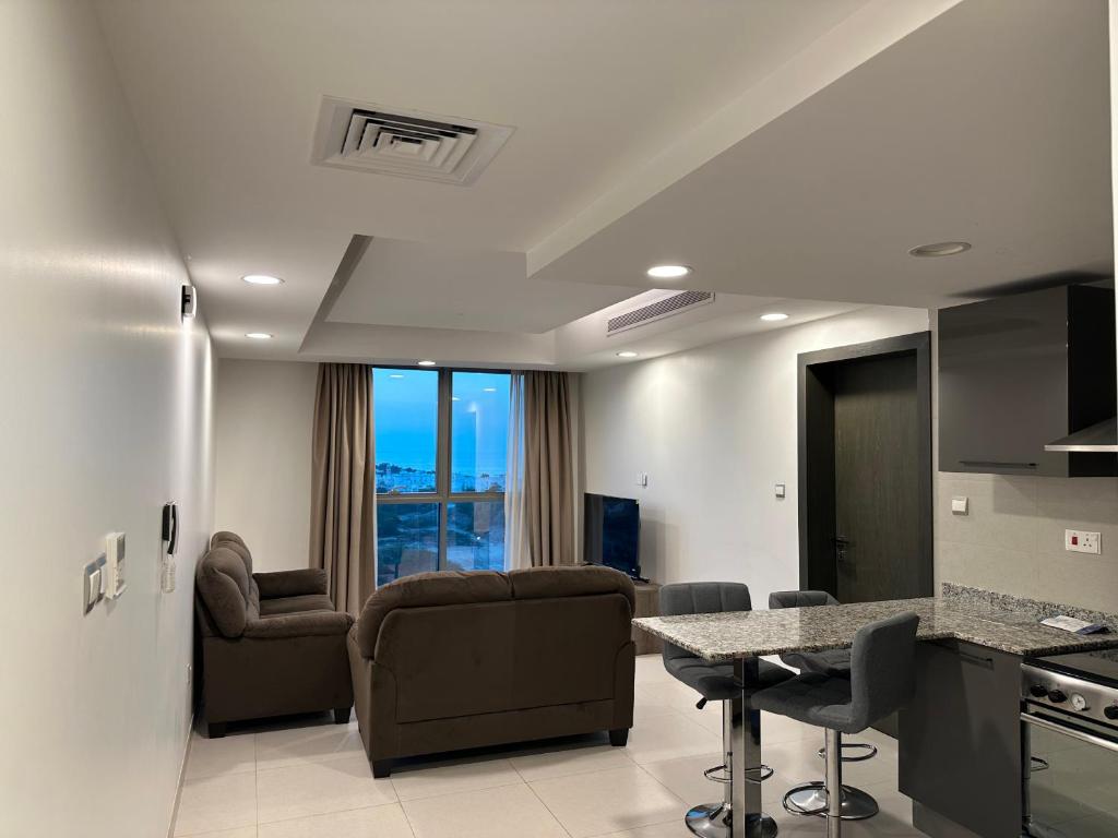 a kitchen and living room with a table and chairs at Pinnacle Row Seaview Elegance in Muscat