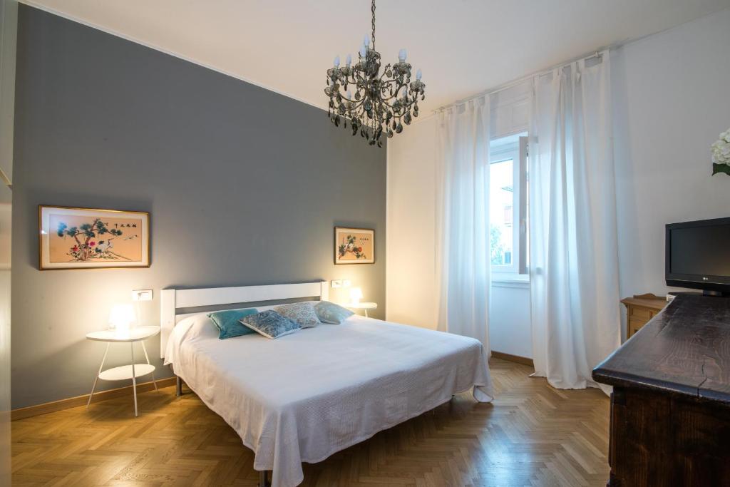 ミラノにあるThe Best Rent - Viale Corsica Apartmentのベッドルーム(白いベッド1台、テレビ付)
