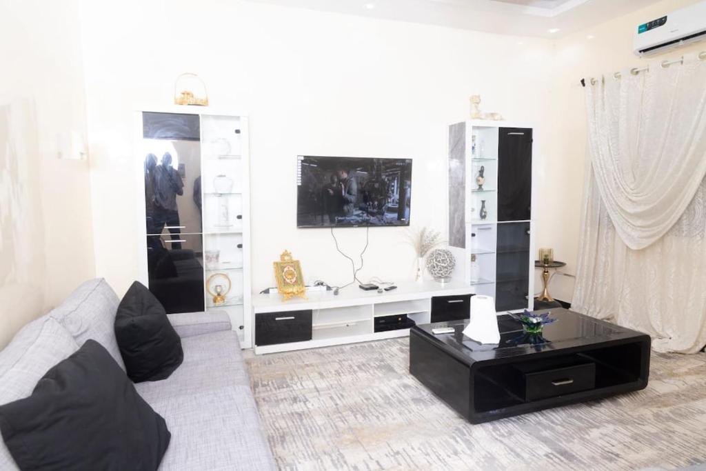Una sala de estar con un sofá y una mesa de café. en Logement entier appartement Mariste, en Hann