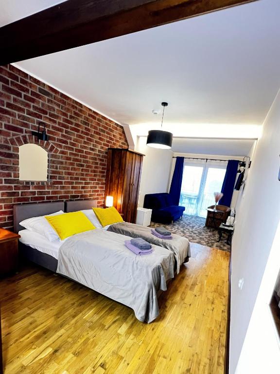 a bedroom with a bed and a brick wall at "U Chłopa" Kompleks Wypoczynkowo-Konferencyjny in Chmielno