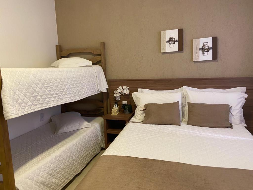 a bedroom with two bunk beds and a table at Pousada Natália in Torres