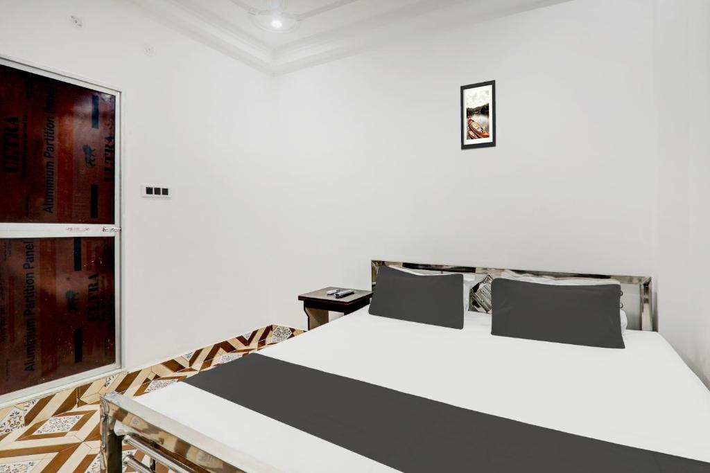 a bedroom with a white bed and a tv at Hotel O Relax Inn in Patna