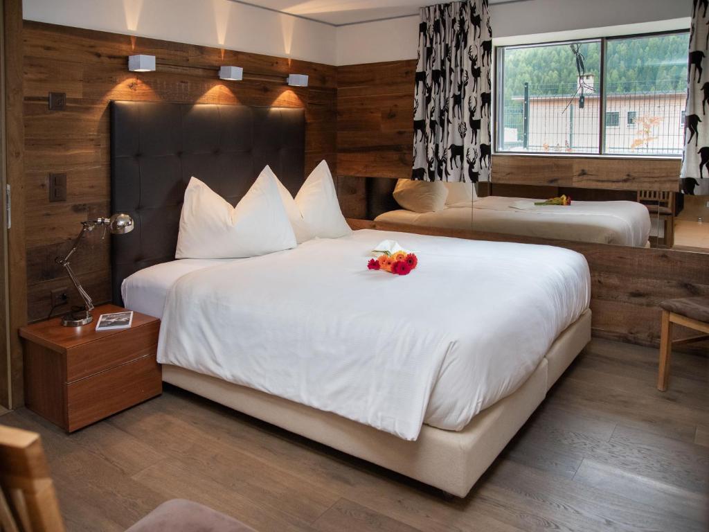Una habitación de hotel con una cama grande con flores. en Apartment Chesa Piz Mezdi - St- Moritz by Interhome, en St. Moritz