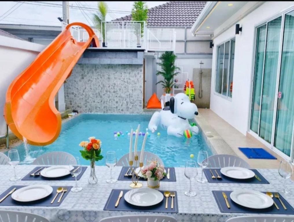 a pool with a slide and an elephant in a backyard at the time pool villa พัทยา in Ban Bung
