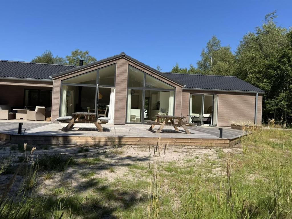 a house with a patio with two picnic tables at Holiday Home Aarthi - 575m from the sea by Interhome in Læsø