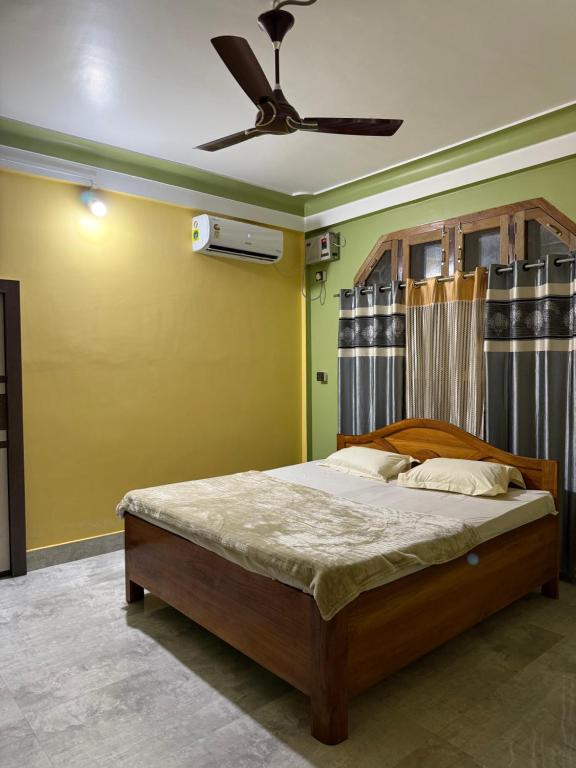 a bedroom with a bed with a ceiling fan at The Family Haven Homestay in Golāghāt