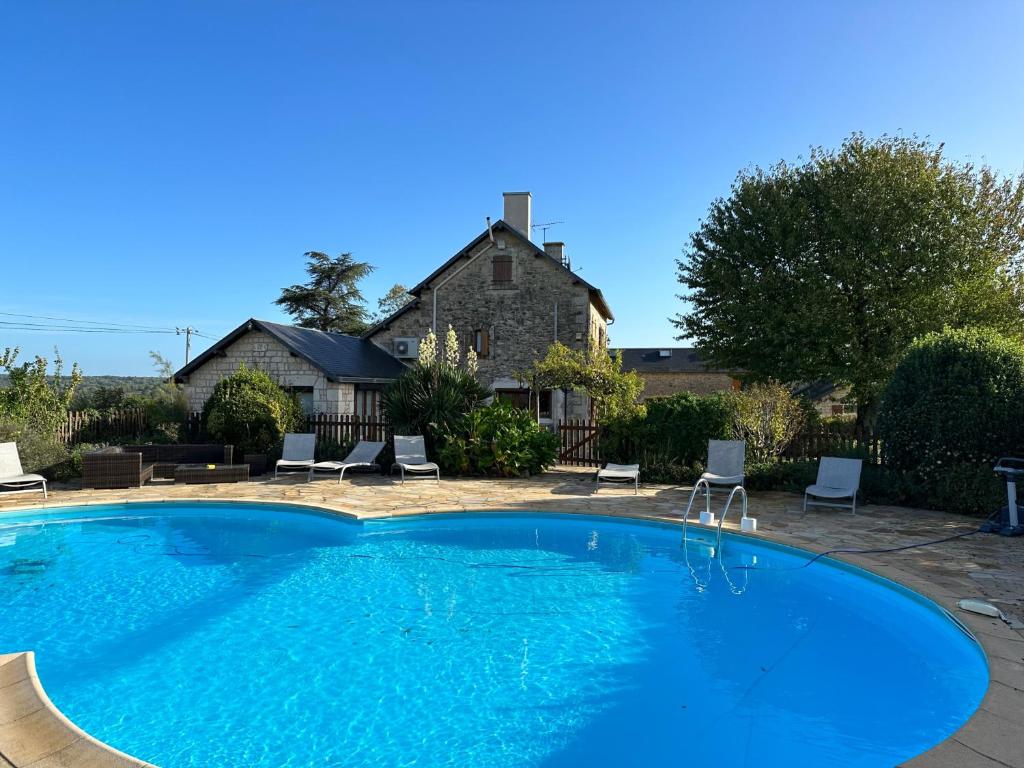 a large blue swimming pool in front of a house at Charming Countryside Retreat in Saint-Georges in Clavé