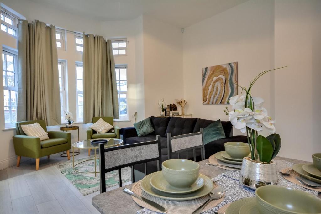 a living room with a couch and a table at Cosy Wigan Apartment with Sunny Views in Wigan