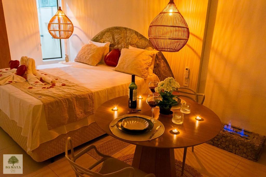 a bedroom with a bed and a table with candles at DA MATA Chalés in Lindóia