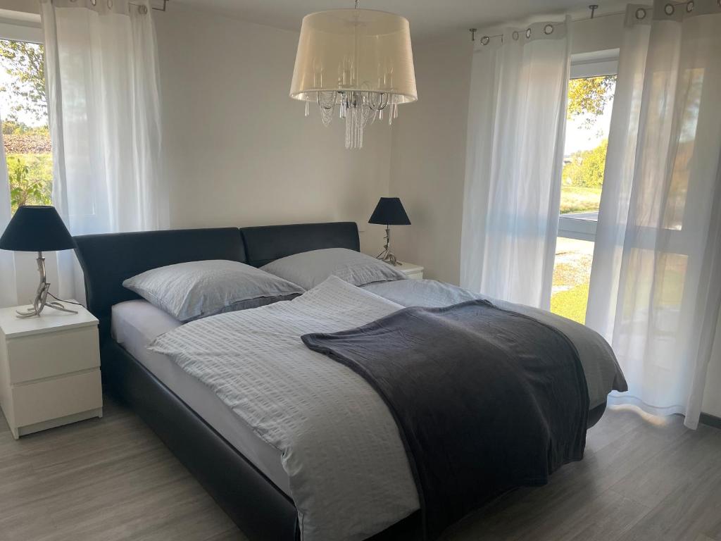 a bed in a bedroom with a chandelier and windows at Helgas Horizon in Rottweil