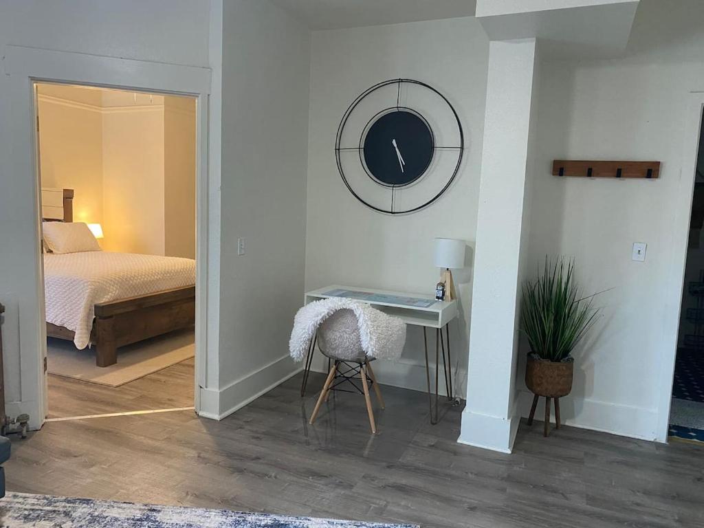 a bedroom with a bed and a table with a chair at 216 The Governors Suite at The George in Klamath Falls