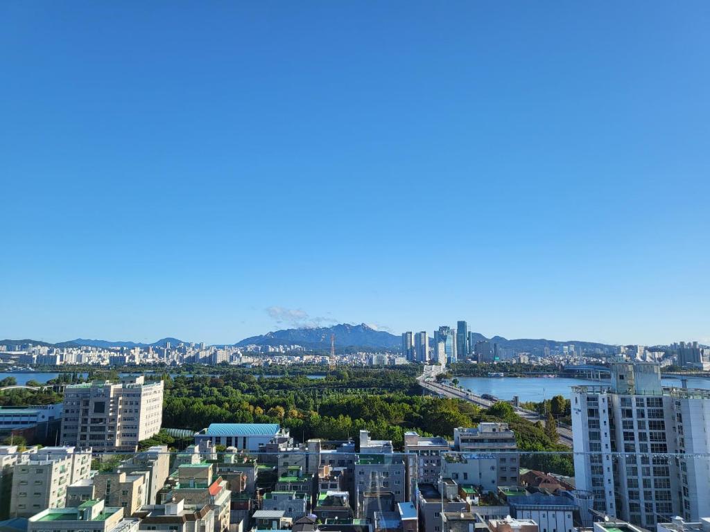 an aerial view of a city with a river and buildings at SunU Seoul Stay - All Rooms 45m Panoramic Han River View - 4m Ceiling in Seoul