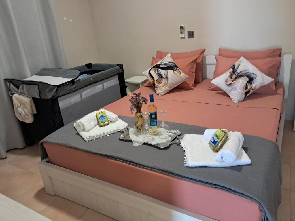 two beds in a room with towels and wine bottles at Villa Nicole in Katarrákhion