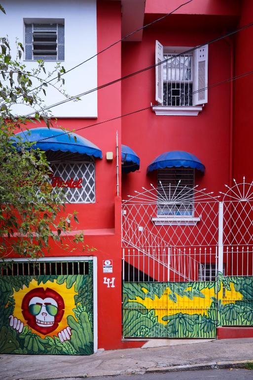 a red building with a painting on the side of it at Red Monkey Hostel Barra Funda in São Paulo