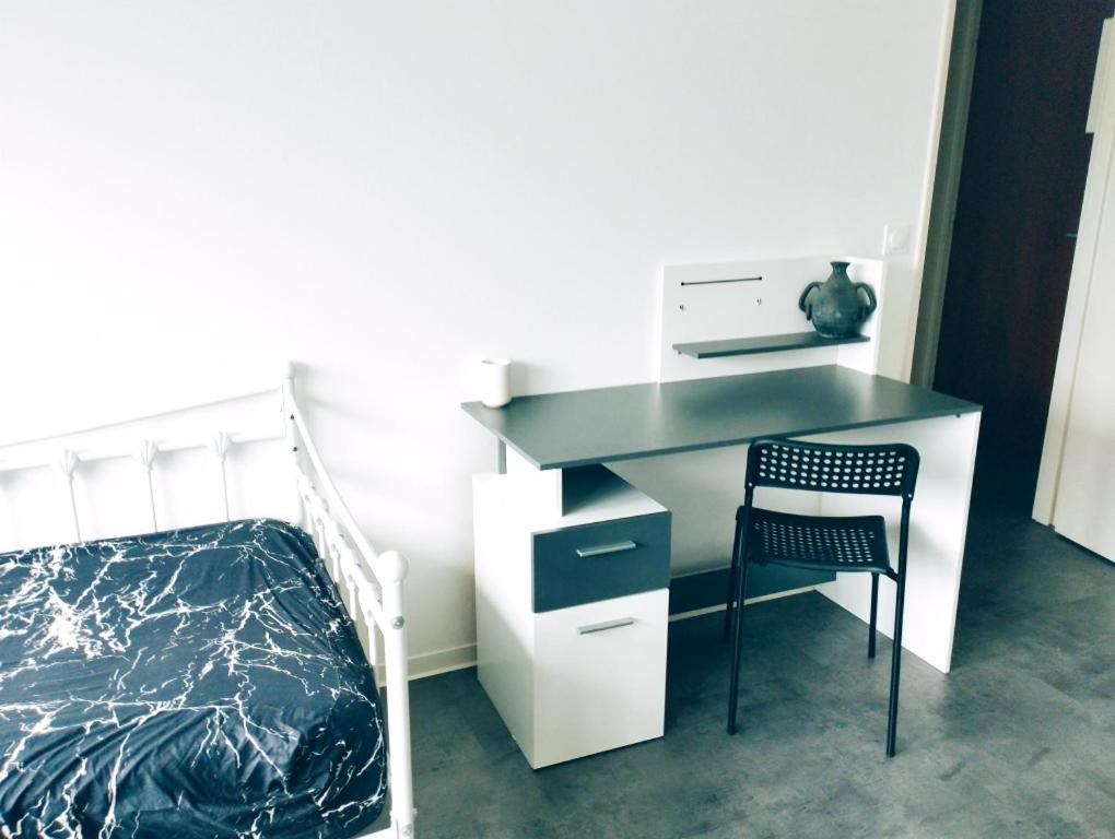 a bedroom with a desk with a bed and a chair at P' TI ECRIN DE VERDURE in Illzach