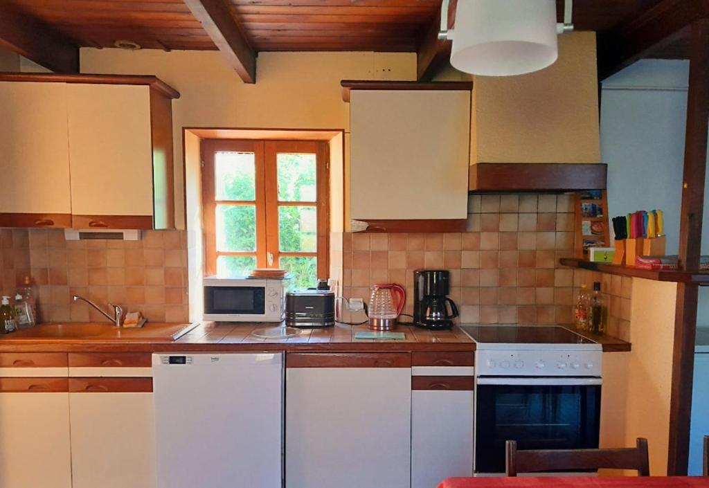 a kitchen with white appliances and a window at Maison sur la Presqu'île de Plougastel in Plougastel-Daoulas